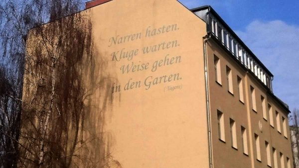 Hausaufschrift: Narren hasten, Kluge warten, Weise gehen in den Garten