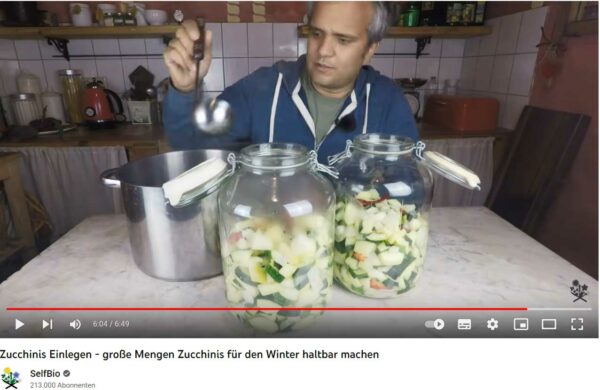 Sascha füllt Sud in große Gläser mit Zucchini